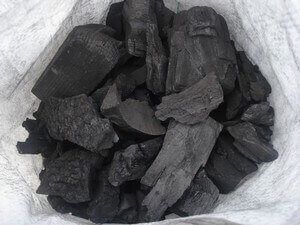 Production de charbon écologique au Cameroun : des ouvriers s'affairent autour de fours traditionnels pour transformer des déchets organiques en briquettes de charbon, contribuant ainsi à une exportation durable du charbon camerounais.